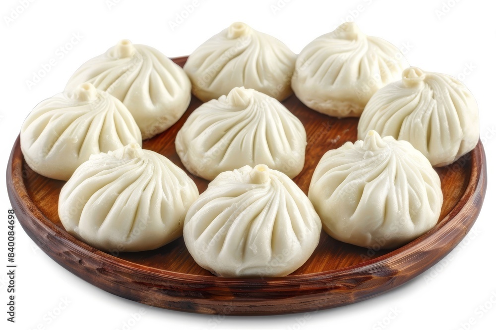 Steamed xiaolongbao dumplings on a wooden plate, a traditional Chinese delicacy Steamed xiaolongbao dumplings on a wooden plate, a traditional Chinese delicacy