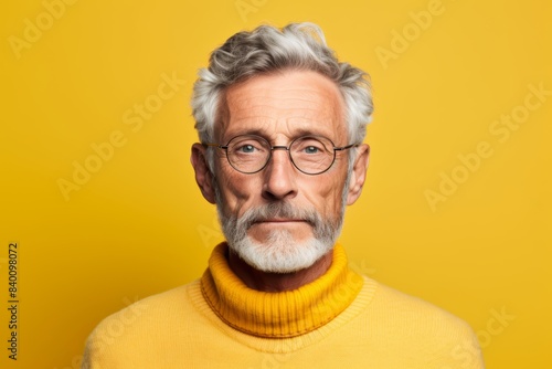 Man with a mesmerizing gaze, aged 65 and older, on a light yellow background © Hanna Haradzetska