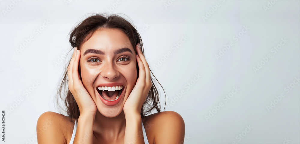 Naklejka premium A woman with a big smile on her face, her hands on her face. She looks happy and excited. a beautiful woman with a face full of excitement and joy, is smiling. White background