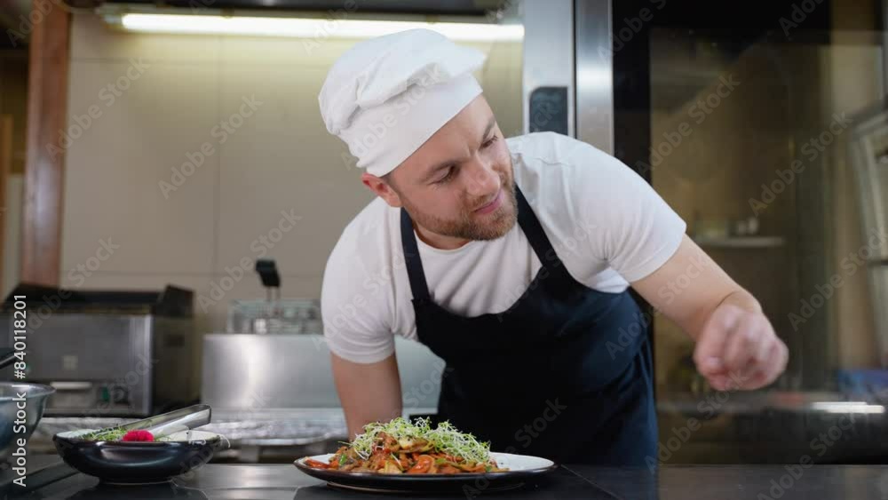Chef is decorating asian dish. Cooking fried vegetables. Asian cuisine