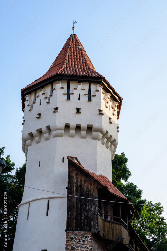 Large old white painted stone tower in the historical center of the Sibiu city, near Citadel Street and Park (Strada si Parcul Cetatii), in Transylvania (Transilvania) region of Romania, in summer. Large old white painted stone tower in the historical center of the Sibiu city, near Citadel Street and Park (Strada si Parcul Cetatii), in Transylvania (Transilvania) region of Romania, in summer.