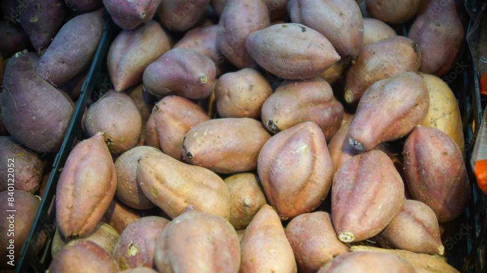 Stacks of sweet potatoes on display at a vegetable store Stacks of sweet potatoes on display at a vegetable store