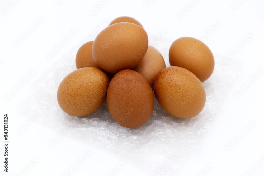 Bubble wrap with eggs on white background. Close-up chicken egg texture. Concept of fresh and healthy ingredients for cooking, farm products, good food, and packing fragile items. Eggs on bubble wrap. Bubble wrap with eggs on white background. Close-up chicken egg texture. Concept of fresh and healthy ingredients for cooking, farm products, good food, and packing fragile items. Eggs on bubble wrap.