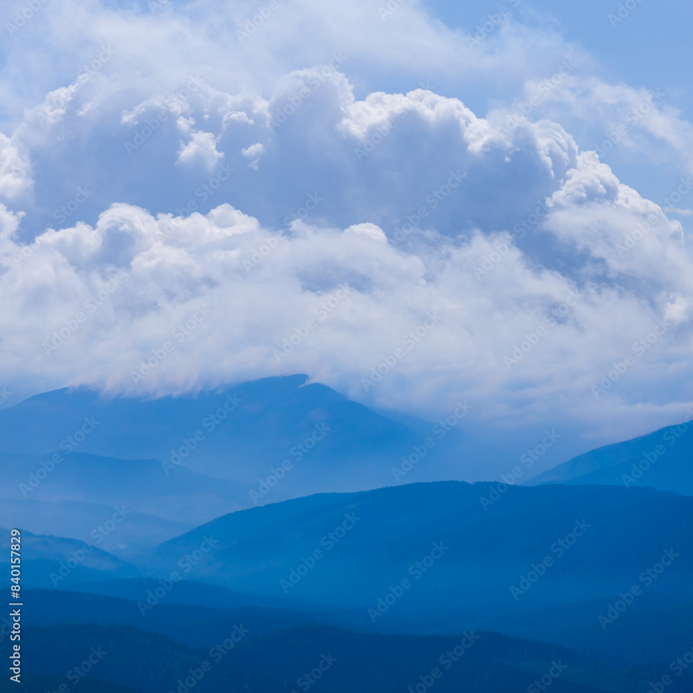 Obraz premium mountain ridge silhouette in mist and dense clouds