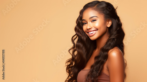 Beautiful, sexy, happy smiling dark-skinned African American woman with perfect skin and long hair, on a creamy beige background, banner.