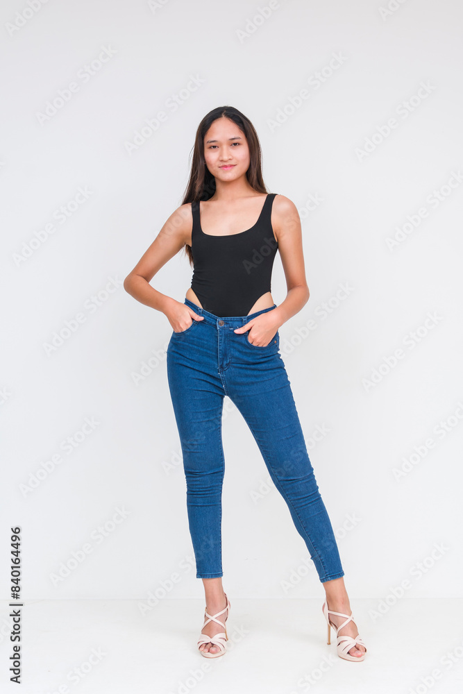 Front view of a young asian woman in a black bodysuit and jeans Isolated on a white background. Hands in pockets. Whole body photo. Front view of a young asian woman in a black bodysuit and jeans Isolated on a white background. Hands in pockets. Whole body photo.