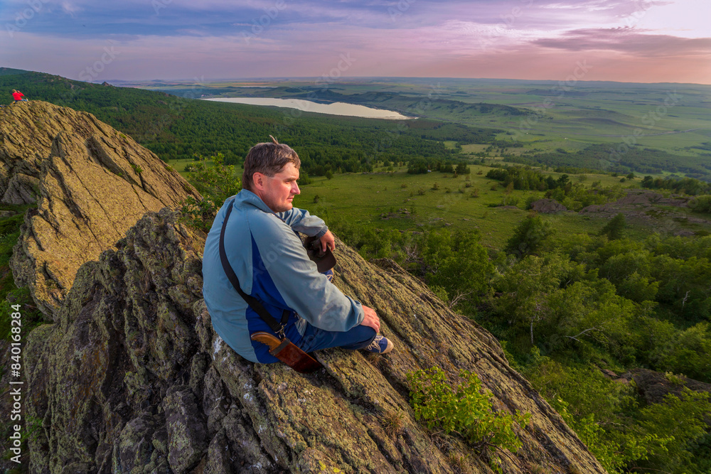 Fototapeta premium a young handsome man travels through the mountains of the Southern Urals on a summer day