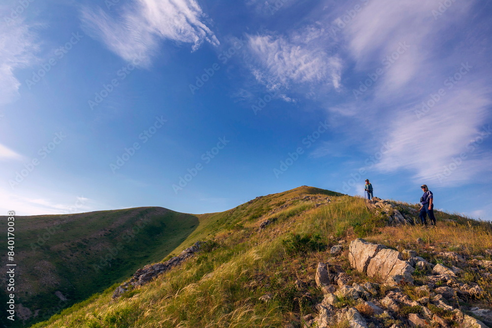 tourists men and women walk along the ridges of the Southern Urals on a summer day. Karamuruntau ridge, tourists men and women walk along the ridges of the Southern Urals on a summer day. Karamuruntau ridge,