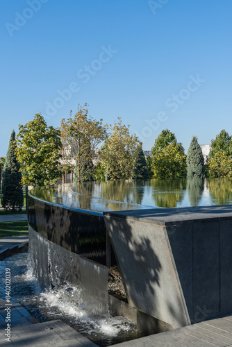 City Park "Krasnodar" or Galitsky Park. Fountain 'Infinity'  in form of huge bowl. Water flows in streams into bed of artificial river. European level. Krasnodar, Russia - September 20, 2023