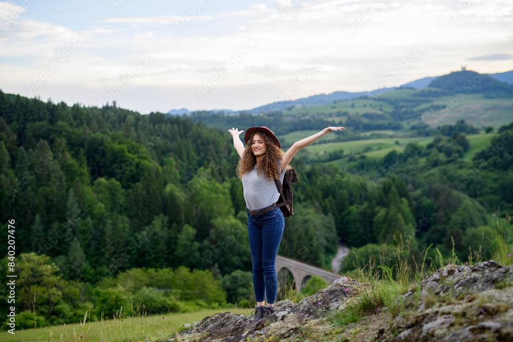 Young tourist woman traveller with backpack walking in nature. Active hiker on trail in mountains. Young tourist woman traveller with backpack walking in nature. Active hiker on trail in mountains.