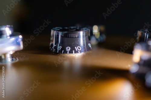 close-up of a volume control of an electric guitar in shadow light