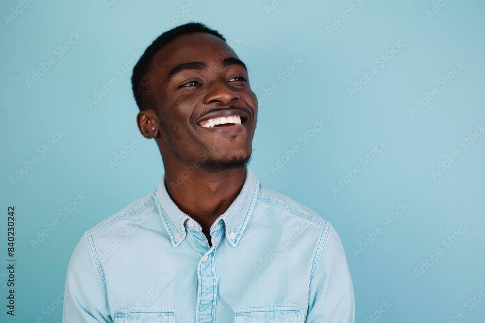 A happy young man smiling while wearing a blue shirt A happy young man smiling while wearing a blue shirt
