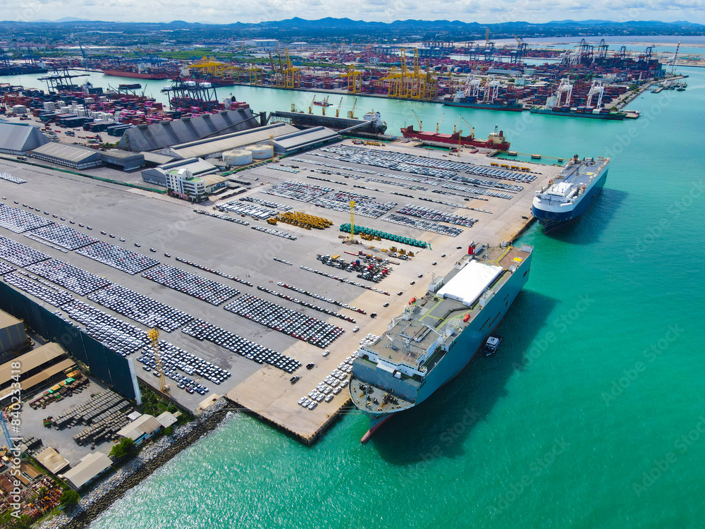 the aerial perspective of a cargo ship being loaded and unloaded at a ...