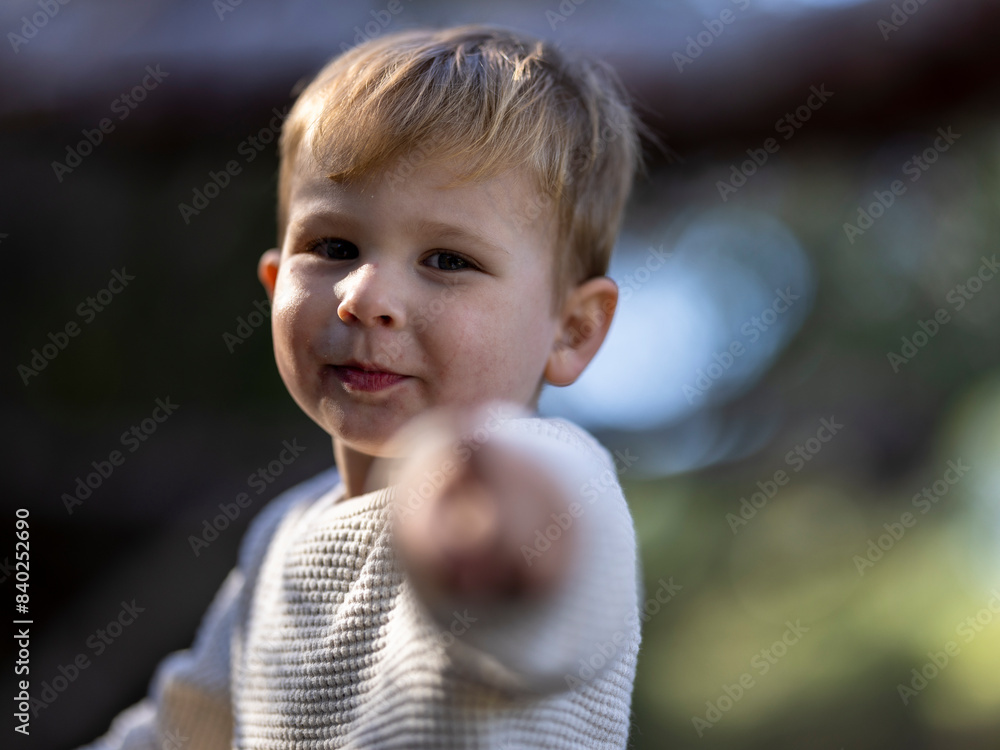 Blonde smiling toddler pointing directly