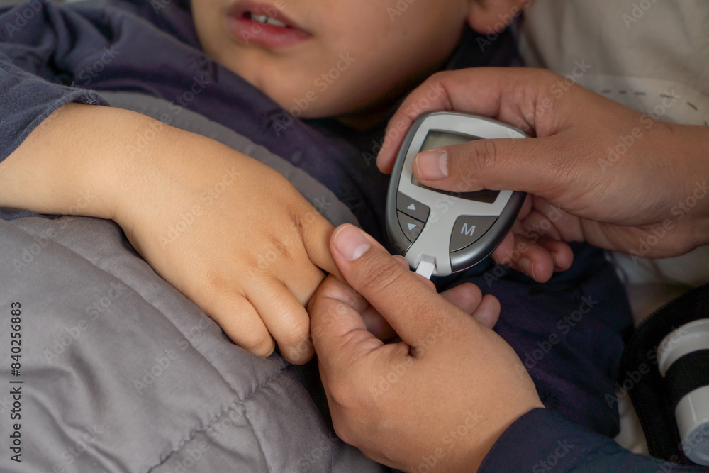 Cropped unrecognizable child receives glucose check during hypoglycemia episode by mother Cropped unrecognizable child receives glucose check during hypoglycemia episode by mother