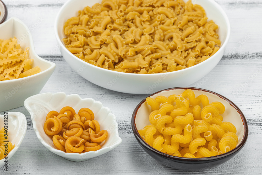 Pasta. Various kinds of uncooked pasta and noodles over wooden background Pasta. Various kinds of uncooked pasta and noodles over wooden background