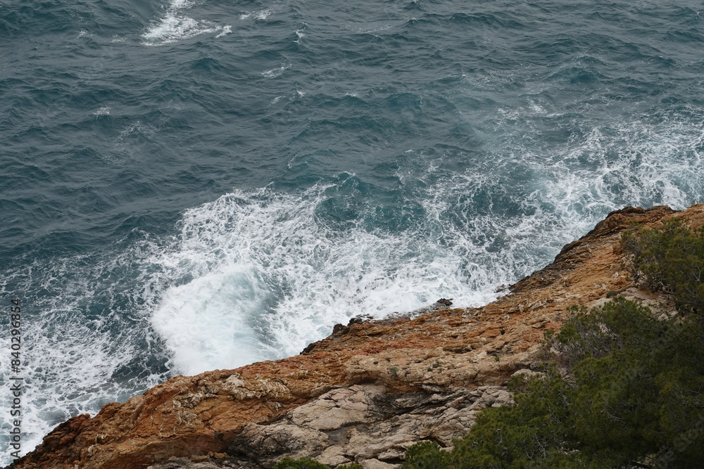 Fototapeta premium Rochers rouges balayés par les vagues sur la côte bleue dans les calanques