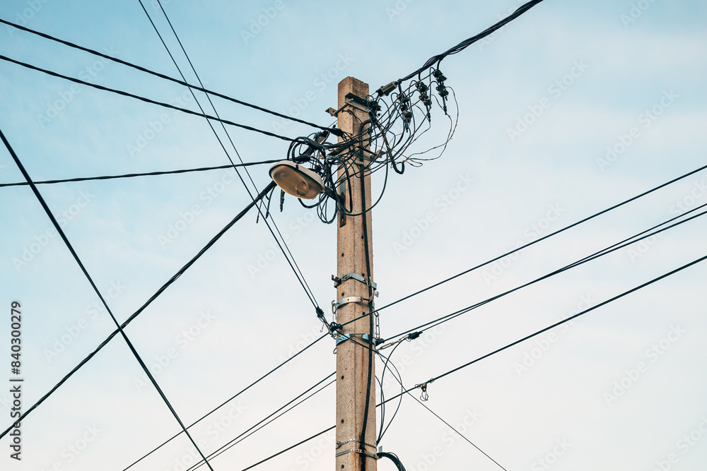 Street light with electricity utility pole and messy electrical wires, low angle view Street light with electricity utility pole and messy electrical wires, low angle view