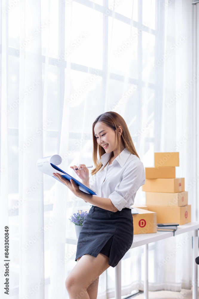 Portrait of Starting small businesses SME owners female entrepreneurs working on receipt box and check online orders to prepare to pack the boxes, sell to customers, SME business ideas online.
