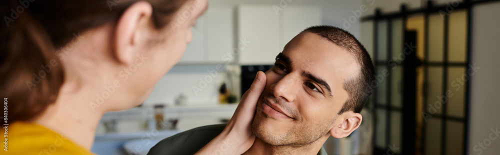 Obraz premium A young gay couple shares a tender moment in their modern apartment, showcasing their love and connection.