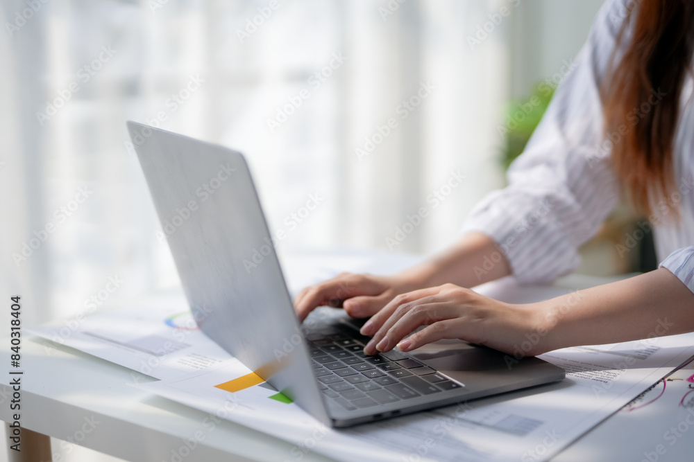 Close-up of person's hands typing on a laptop keyboard at a white desk with documents, showcasing productivity in a modern workspace. Close-up of person's hands typing on a laptop keyboard at a white desk with documents, showcasing productivity in a modern workspace.