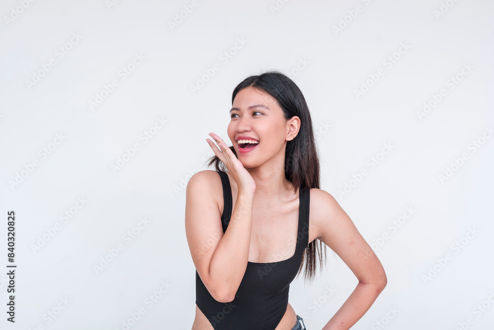 A fresh looking beautiful asian woman smiling and reacting to compliments, wearing a black bodysuit. Isolated on white background. A fresh looking beautiful asian woman smiling and reacting to compliments, wearing a black bodysuit. Isolated on white background.