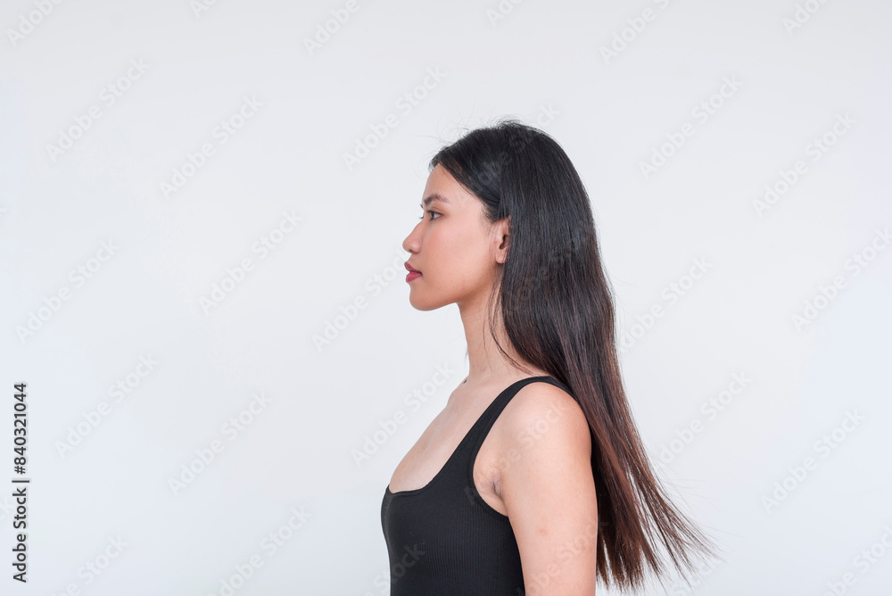 Stoic young asian lady in a black bodysuit or tank top. Side view, isolated on white background. Stoic young asian lady in a black bodysuit or tank top. Side view, isolated on white background.