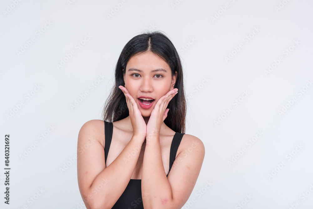 Fresh looking dame in a black bodysuit expressing excitement. Hands on cheeks. Isolated on a white background. Fresh looking dame in a black bodysuit expressing excitement. Hands on cheeks. Isolated on a white background.