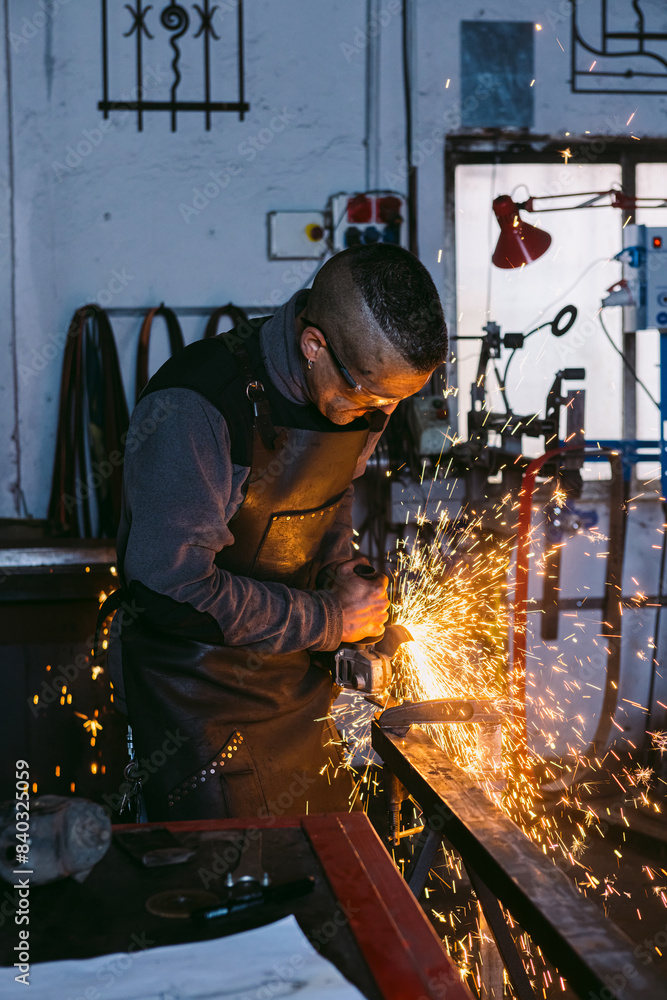 Blacksmith working with grinder in workshop Blacksmith working with grinder in workshop