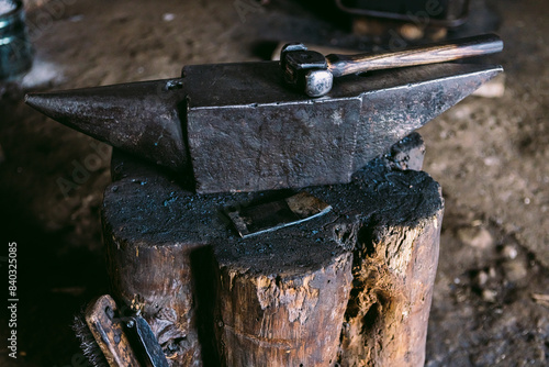 Traditional blacksmith tools on anvil in workshop photo