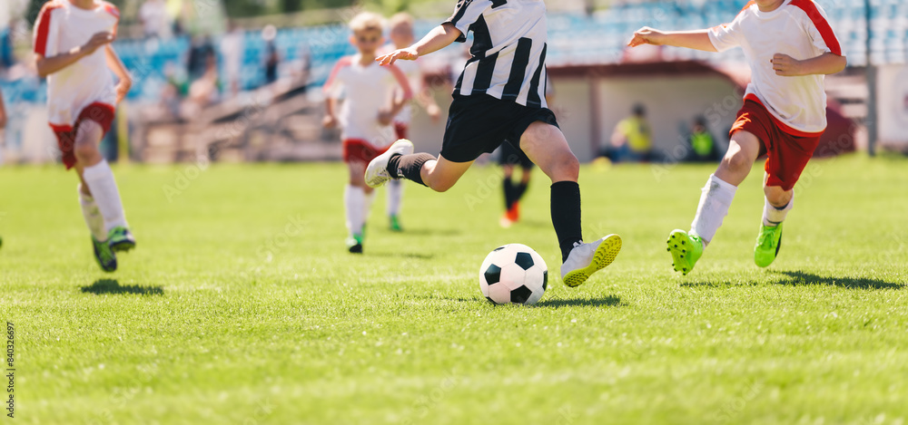 Kids as Football Soccer Players Running with Ball. Footballers Kicking Play League Match During Sunny Day. Two Teams in Sport Competition. Teenage Soccer Players Running in a Duel and Kicking Ball Kids as Football Soccer Players Running with Ball. Footballers Kicking Play League Match During Sunny Day. Two Teams in Sport Competition. Teenage Soccer Players Running in a Duel and Kicking Ball