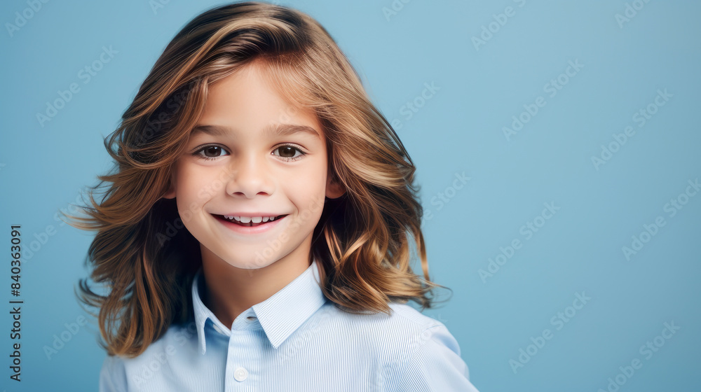 Portrait of a beautiful, happy smiling boy with long hair and perfect skin, light blue background, banner. Portrait of a beautiful, happy smiling boy with long hair and perfect skin, light blue background, banner.