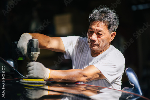 Car polishing, Worker in Auto workshop using color polisher machine polish coating wax in car care. photo