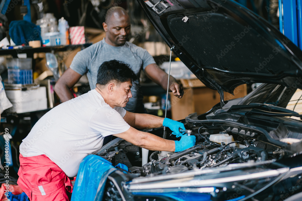 Mechanic team men working together to service fix engine problem in car auto workshop Mechanic team men working together to service fix engine problem in car auto workshop