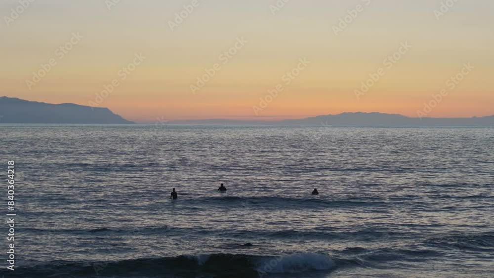 Surfers Catching Waves at Sunset Over the Ocean - A Spectacular Beach Scene in 4k slow motion 60fps Surfers Catching Waves at Sunset Over the Ocean - A Spectacular Beach Scene in 4k slow motion 60fps