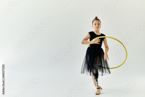 Tablou pe pânză A young girl with a prosthetic leg practices gymnastics with a hoop