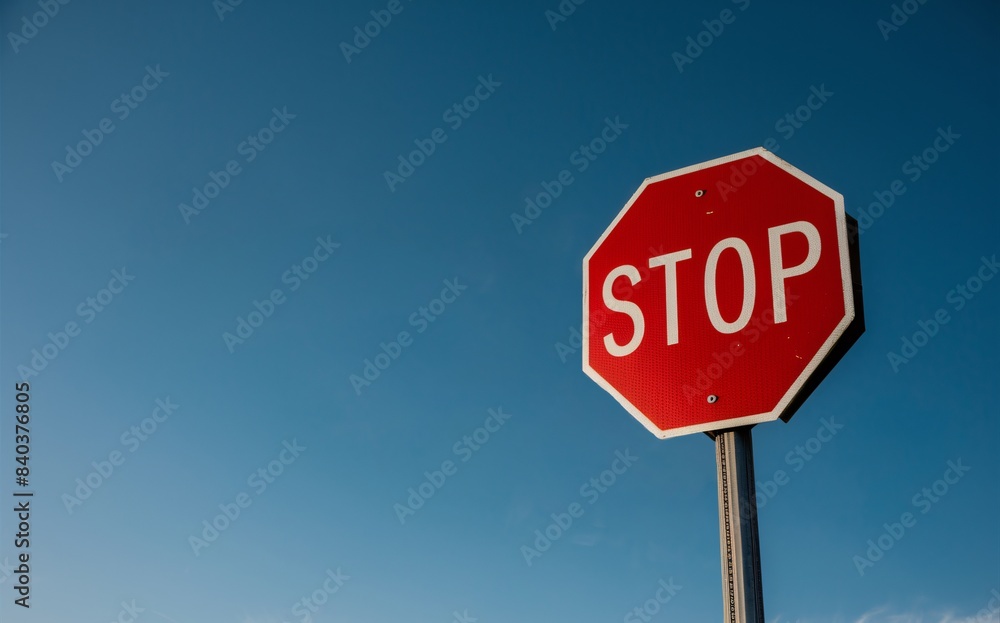 Low angle shot of stop traffic sign against a clear blue sky background. Low angle shot of stop traffic sign against a clear blue sky background.
