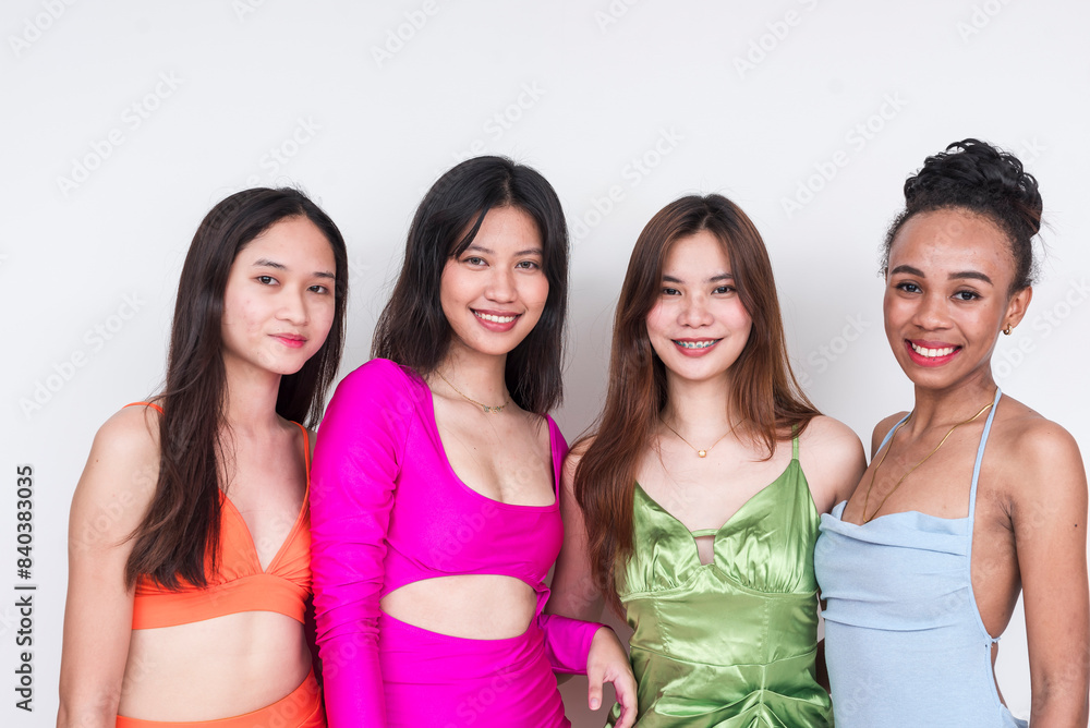 Four young women in vibrant party wear posing together Four young women in vibrant party wear posing together