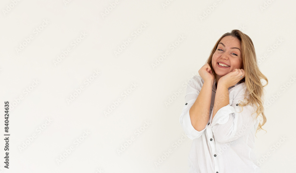 Headshot of pleased high spirit pretty female model, has warm pleasant smile, keeps hands under chin, wears white shirt, isolated over white background. Happiness concept Headshot of pleased high spirit pretty female model, has warm pleasant smile, keeps hands under chin, wears white shirt, isolated over white background. Happiness concept