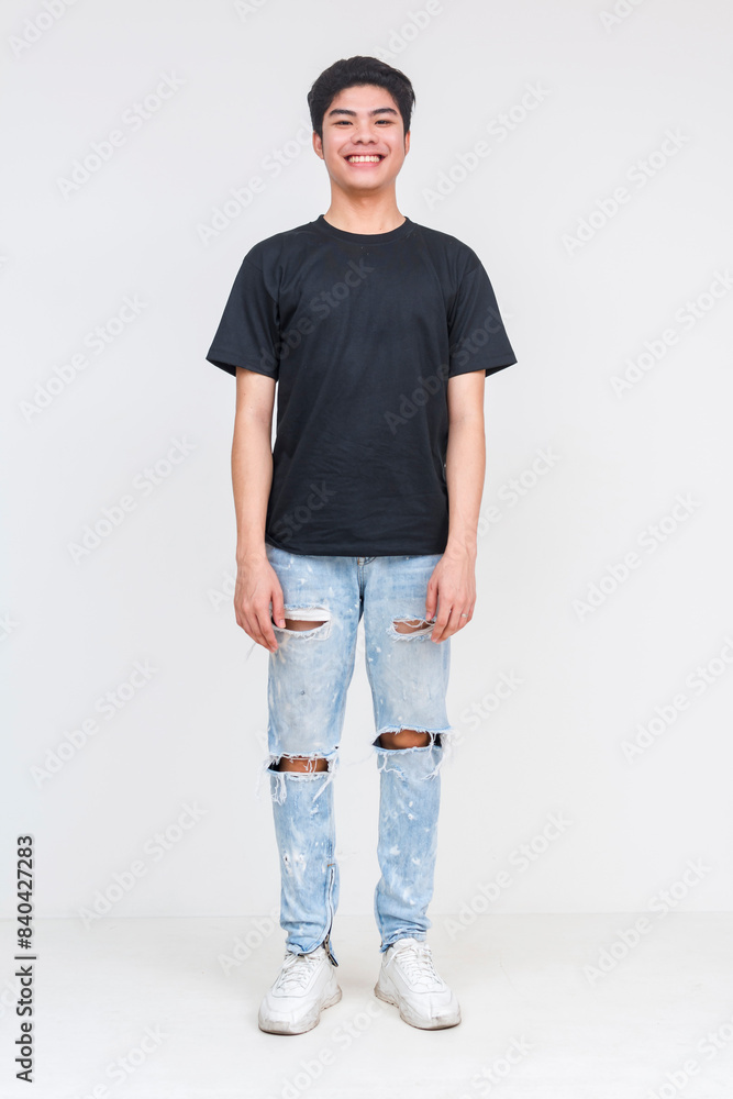 Obraz premium Young man in black shirt and ripped jeans smiling