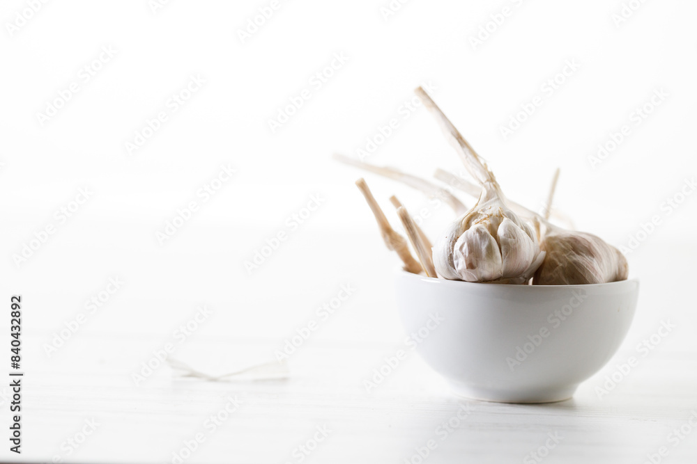 Ripe organic garlic clove and bulb on white wooden background. Close-up. Selective focus. Ripe organic garlic clove and bulb on white wooden background. Close-up. Selective focus.