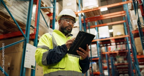 Warehouse, black man and manufacturing with tablet, inventory and checklist in a factory. African person, worker and employee with tech and inspection with digital app for logistics and online stock photo