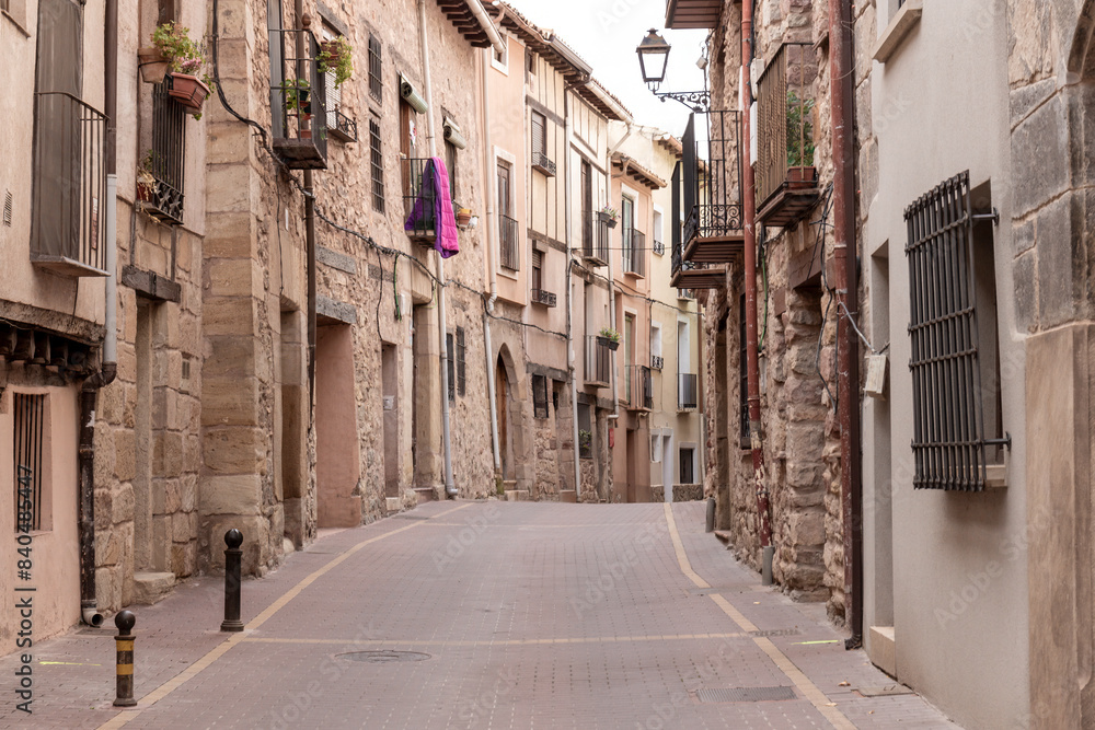 a cobblestone street lined with charming old buildings and a purple cloth hanging from a window a cobblestone street lined with charming old buildings and a purple cloth hanging from a window