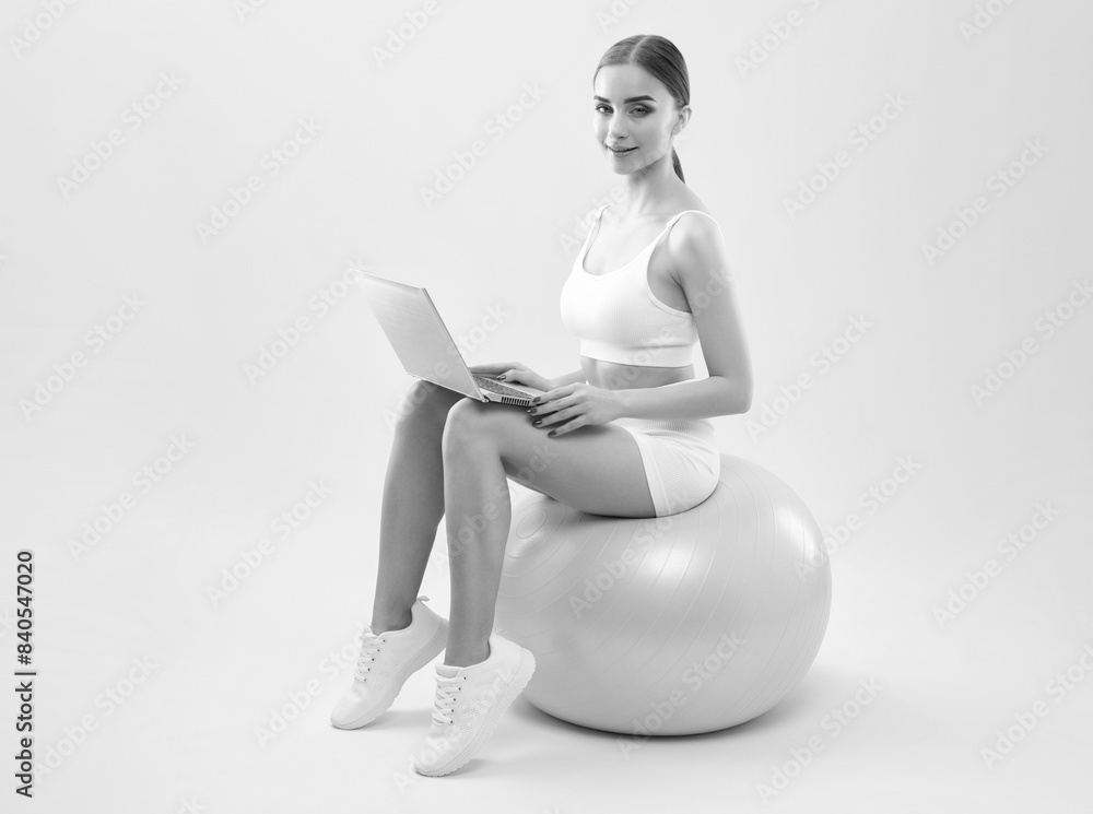 Naklejka premium Slender dark-skinned female blogger in a white tracksuit against a white background. Healthy lifestyle, sports and diet.