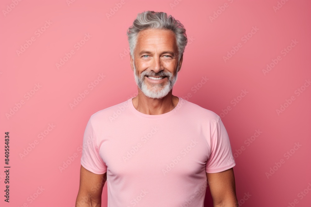 Portrait of a content man in his 60s wearing a moisture-wicking running shirt on pastel gray background Portrait of a content man in his 60s wearing a moisture-wicking running shirt on pastel gray background