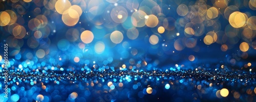An abstract glittering background containing golden christmas lights and a blue glittery background