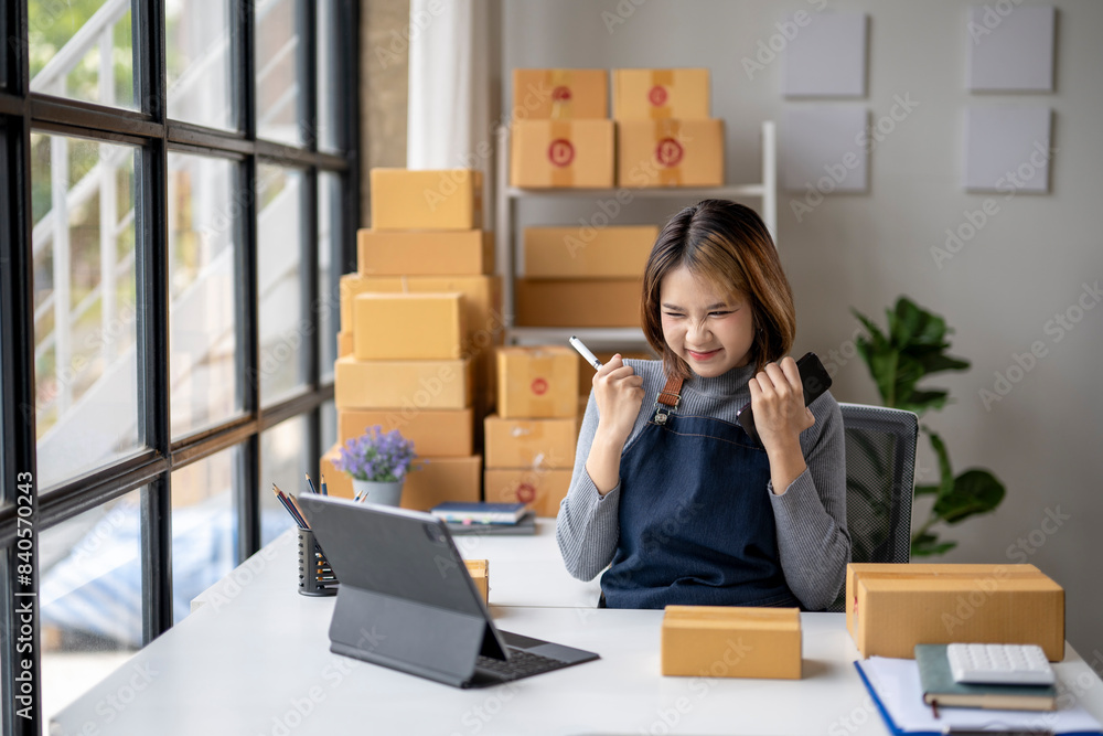 A woman is sitting at a desk with a tablet and a laptop A woman is sitting at a desk with a tablet and a laptop