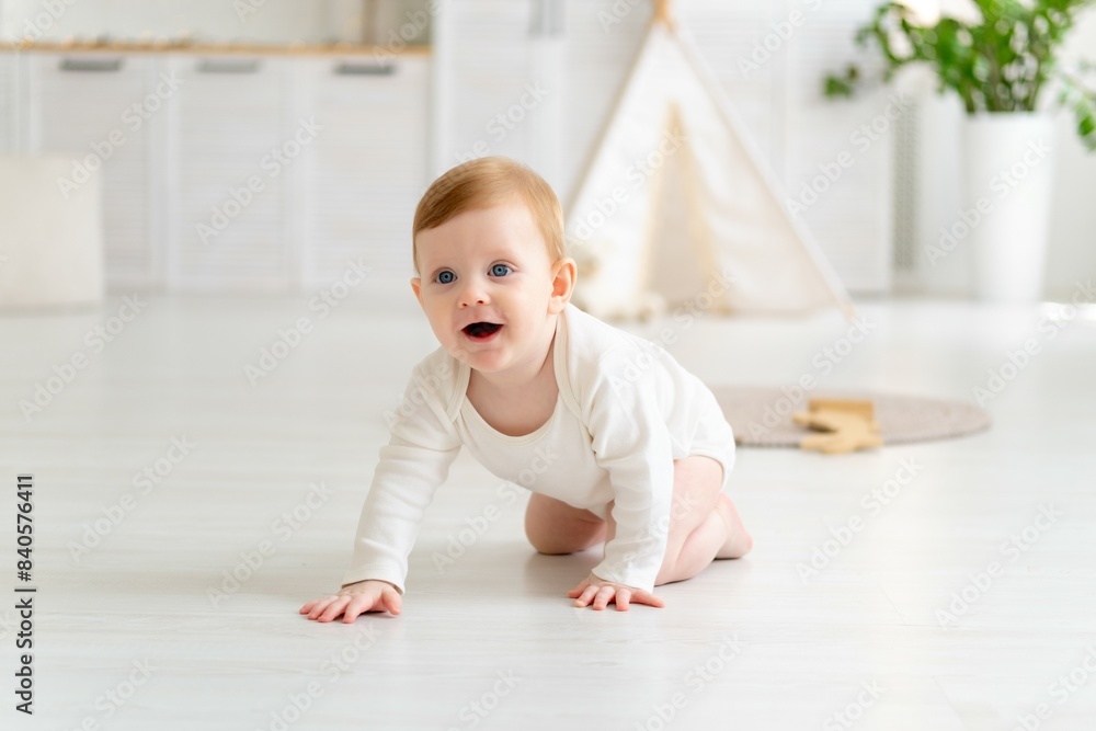 a small smiling child, a boy in a white bodysuit, crawls or learns to crawl on the floor of a house in a bright room with a wigwam, a six-month-old baby with blue eyes smiles or laughs a small smiling child, a boy in a white bodysuit, crawls or learns to crawl on the floor of a house in a bright room with a wigwam, a six-month-old baby with blue eyes smiles or laughs