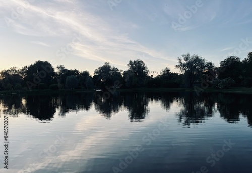 twilights at the park, sky and trees silhouettes reflection on the water surface, pond in the park, evening, summer