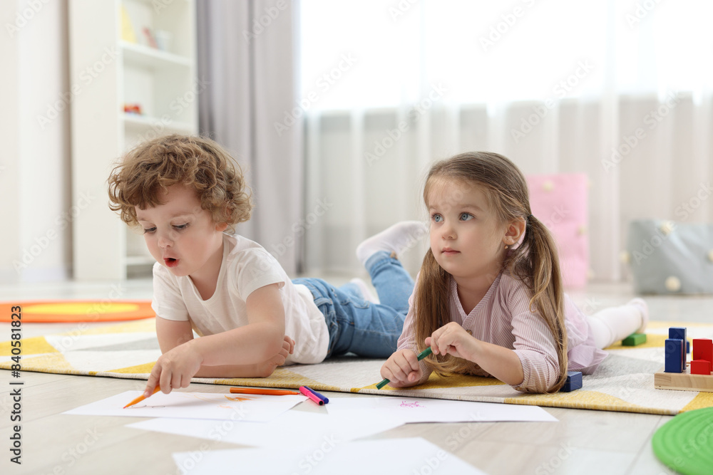 Cute little children drawing on floor in kindergarten Cute little children drawing on floor in kindergarten